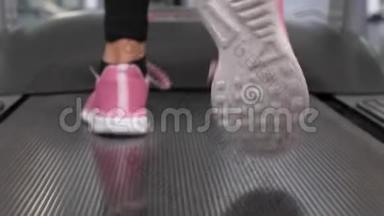 穿运动鞋的女孩的腿在<strong>跑步机</strong>上行走。特写镜头。行走时加强腿部<strong>肌</strong>肉。有氧负荷